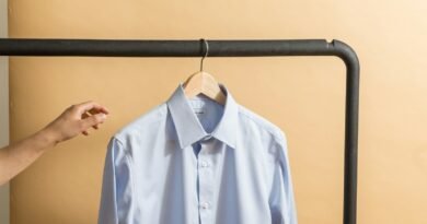 white button up shirt hanging on black metal bar