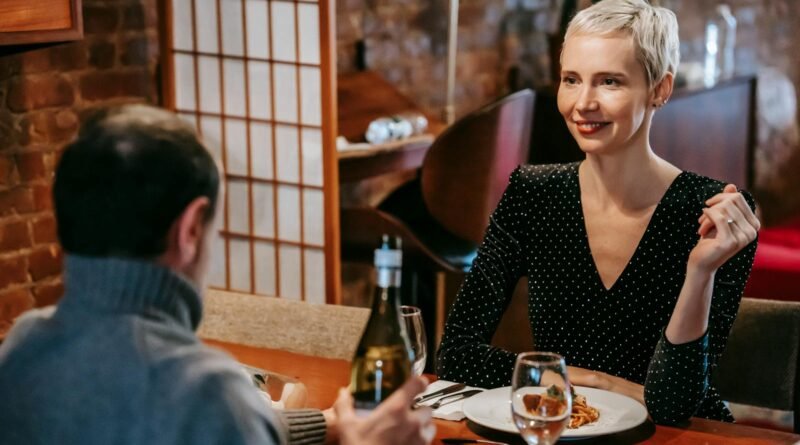 Couple having dinner with pasta and wine in room