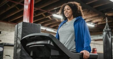 Smiling black woman standing on treadmill