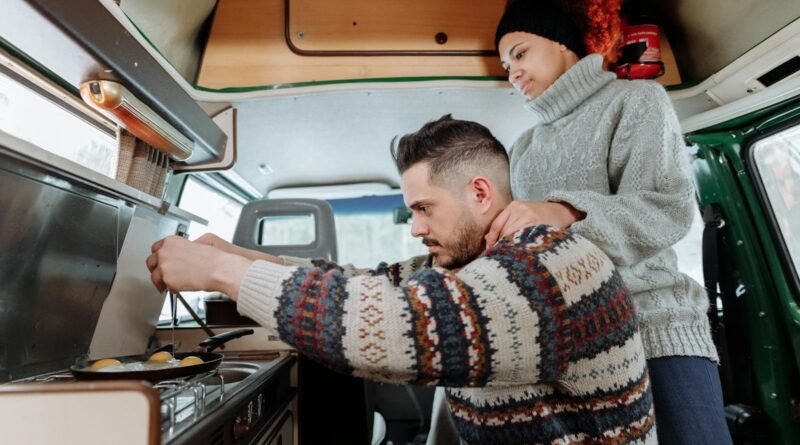 A Man Cooking Eggs using a Stove in Campervan