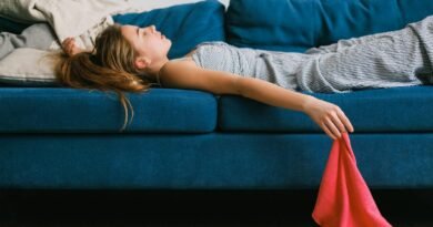 Tired housewife resting on sofa after housework