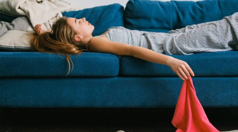 Tired housewife resting on sofa after housework