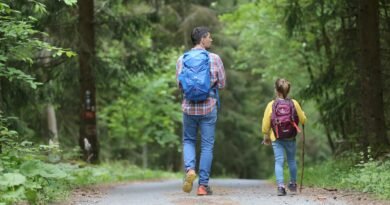 man in blue jacket and blue denim jeans walking on dirt road during daytime