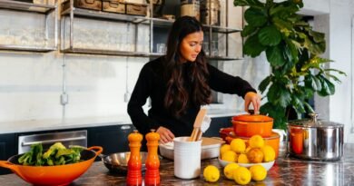 woman standing in front of fruits holding pot's lid