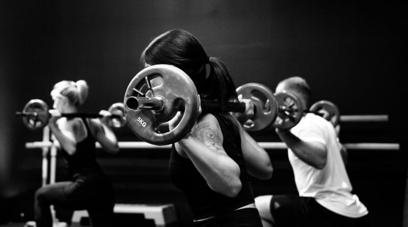 three person lifting barbels