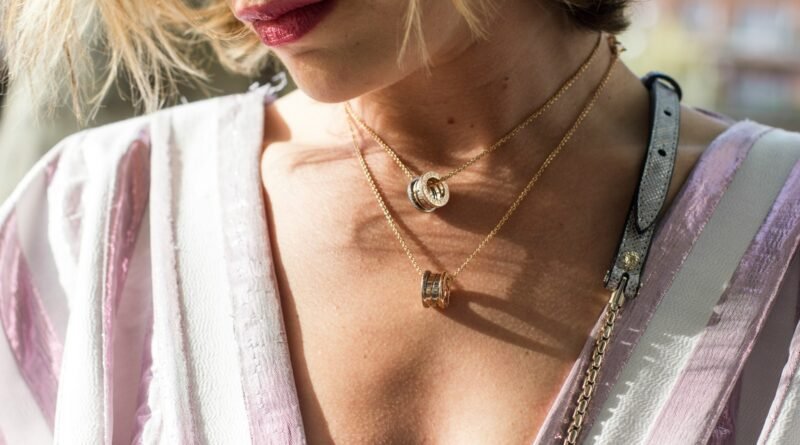 woman wearing gold-colored ring pendant necklaces