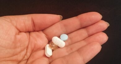 person holding four assorted medicine tablets