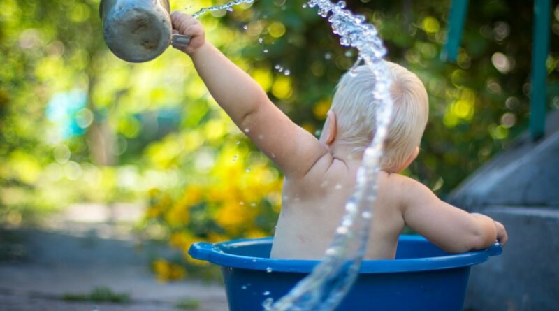 child lifting water dipper