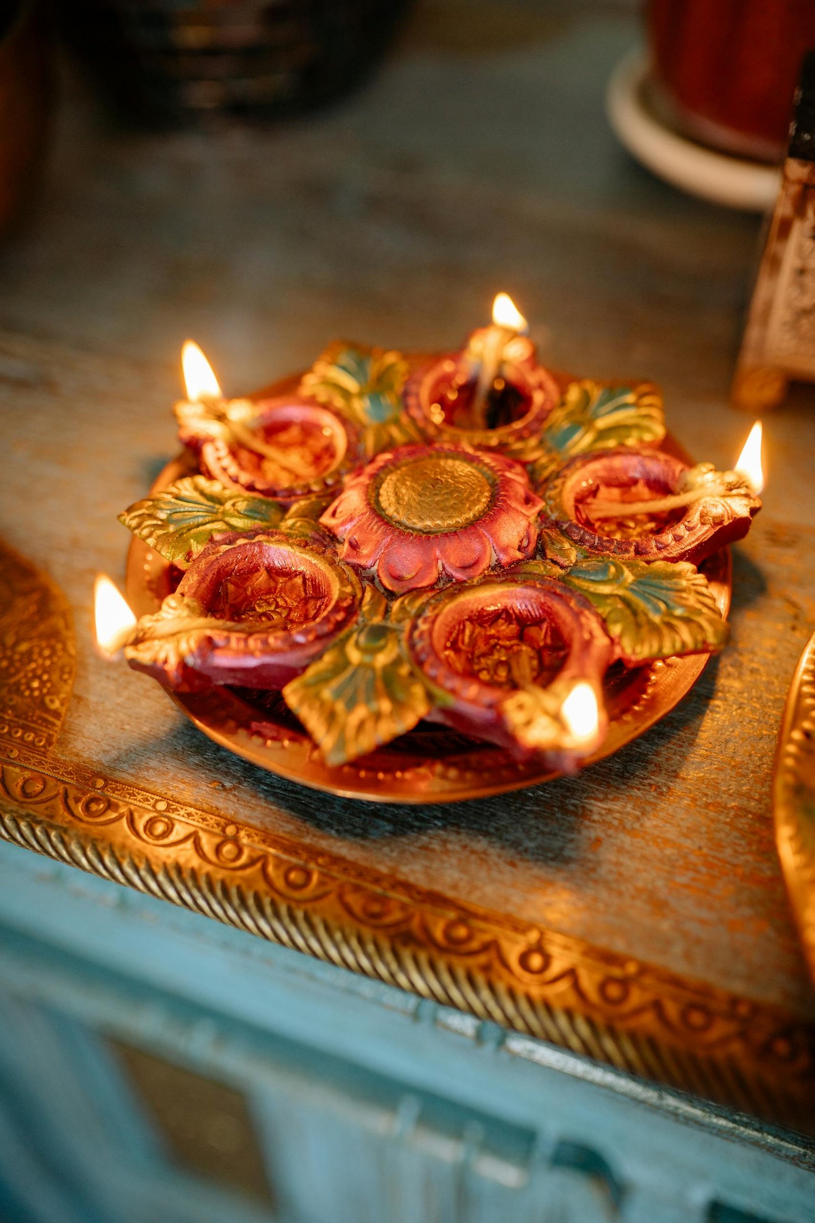 Vibrant decorative Diwali lamps lit on a beautifully ornate plate, creating a festive ambiance.